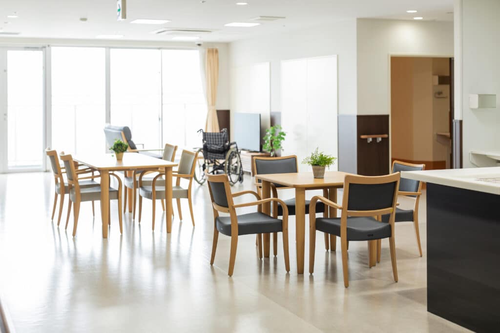 Aged care recreation room showing tables and a wheelchair